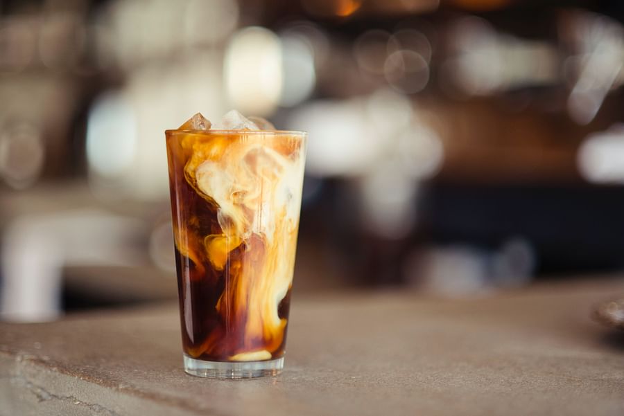 Dark, rich cold brew coffee in a glass, indicating the use of high-quality beans